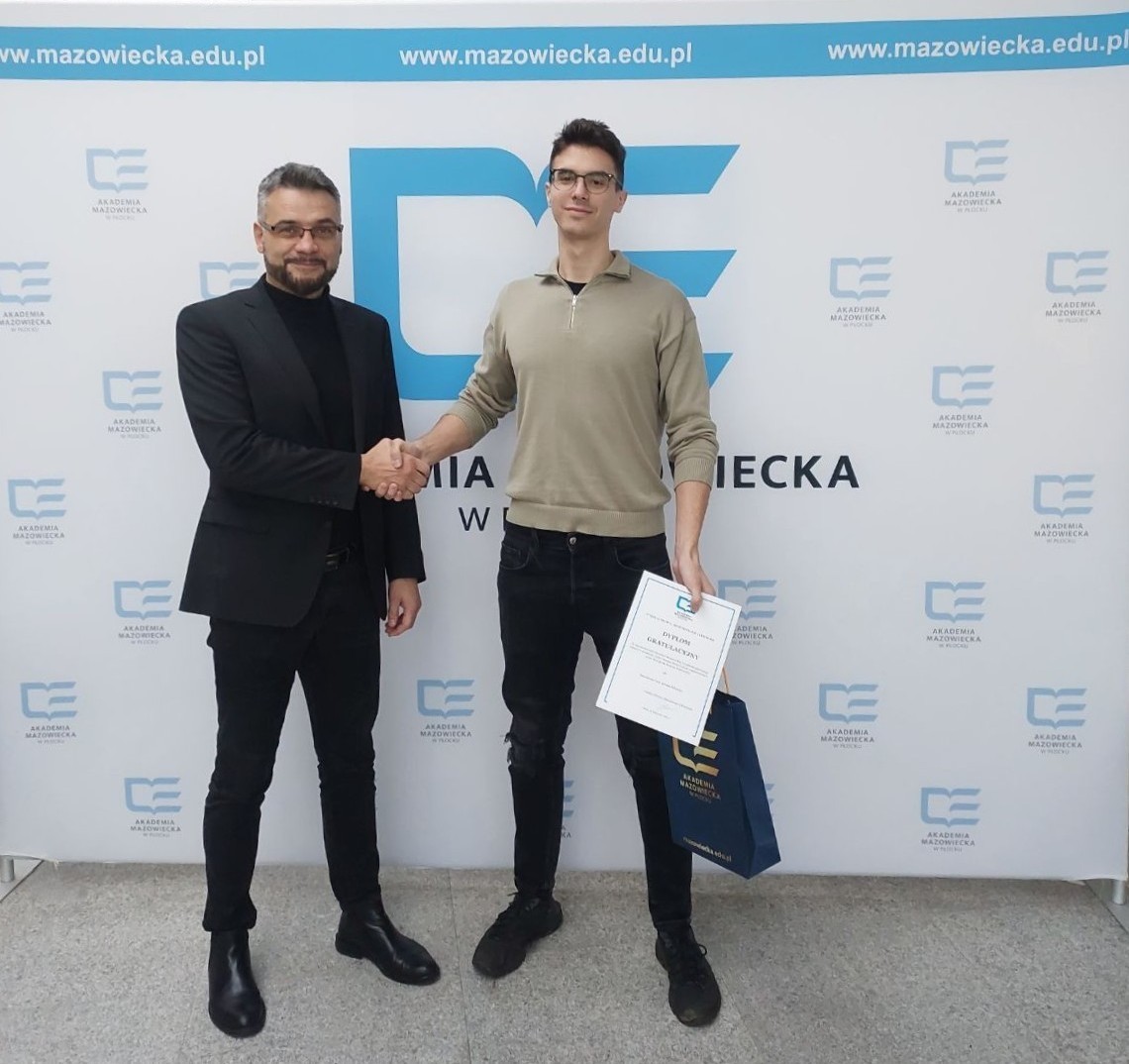 Michał Mielczarek - zwycięzca konkursu Cyber Geniusz Student 2024 przyjmujący gratulacje od Dziekana Wydziału Prawa, Administracji i Ekonomii AMP