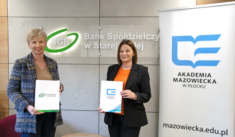 zdjęcie przedstawiające przedstawicielki Akademii Mazowieckiej w Płocku i Banku Spółdzielczego w Starej Białej na tle logotypów instytucji, trzymające teczki z podpisana umową o współpracy