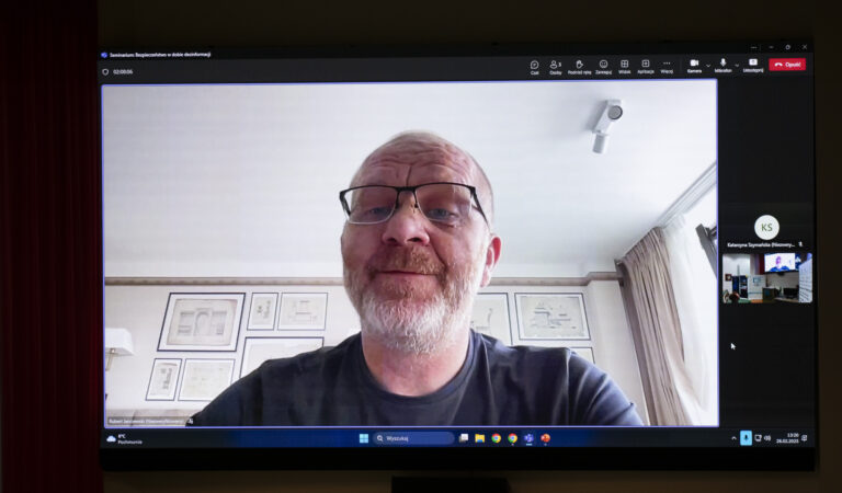Zdjęcie monitora komputera z prelegentem prowadzącym wykład online podczas sympozjum