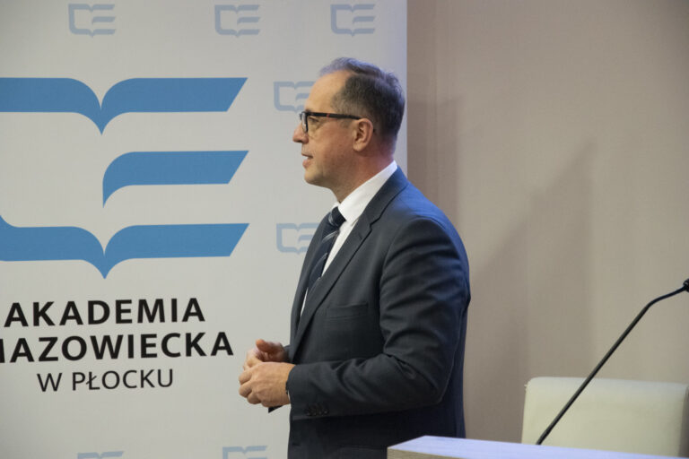 Zdjęcie prowadzącego wykład prelegenta sympozjum przy mównicy