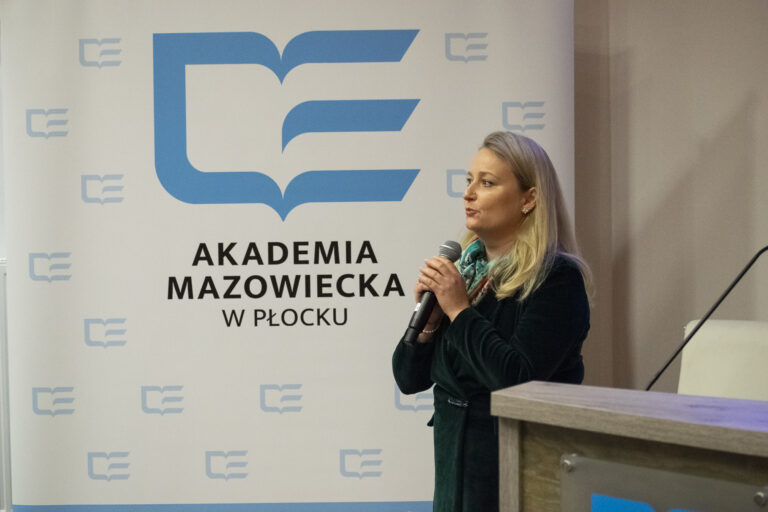 Zdjęcie prowadzącego wykład prelegenta sympozjum przy mównicy