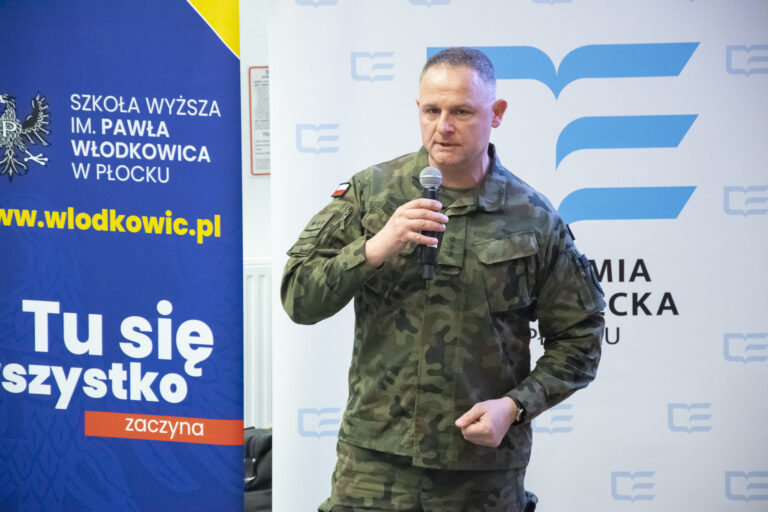 prelegent prowadzący wykład podczas sympozjum, mówiący do mikrofonu