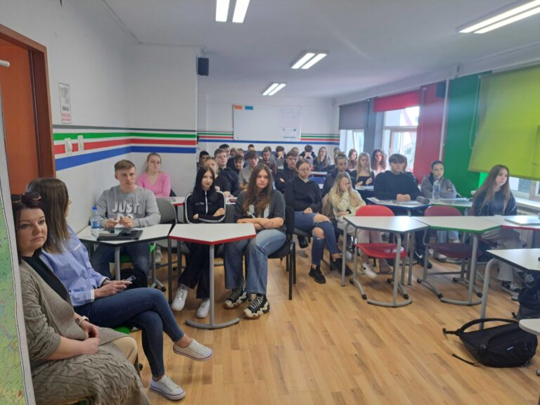 Uczniowie siedzący w klasie w ławkach podczas warsztatów