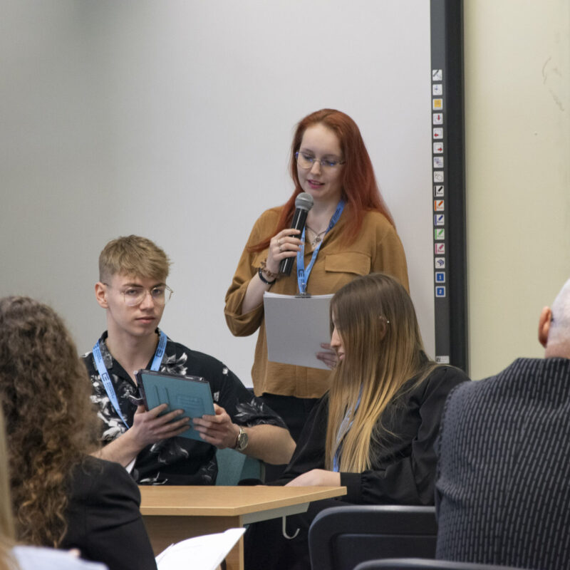 Studentka prelegentka mówiąca do mikrofonu
