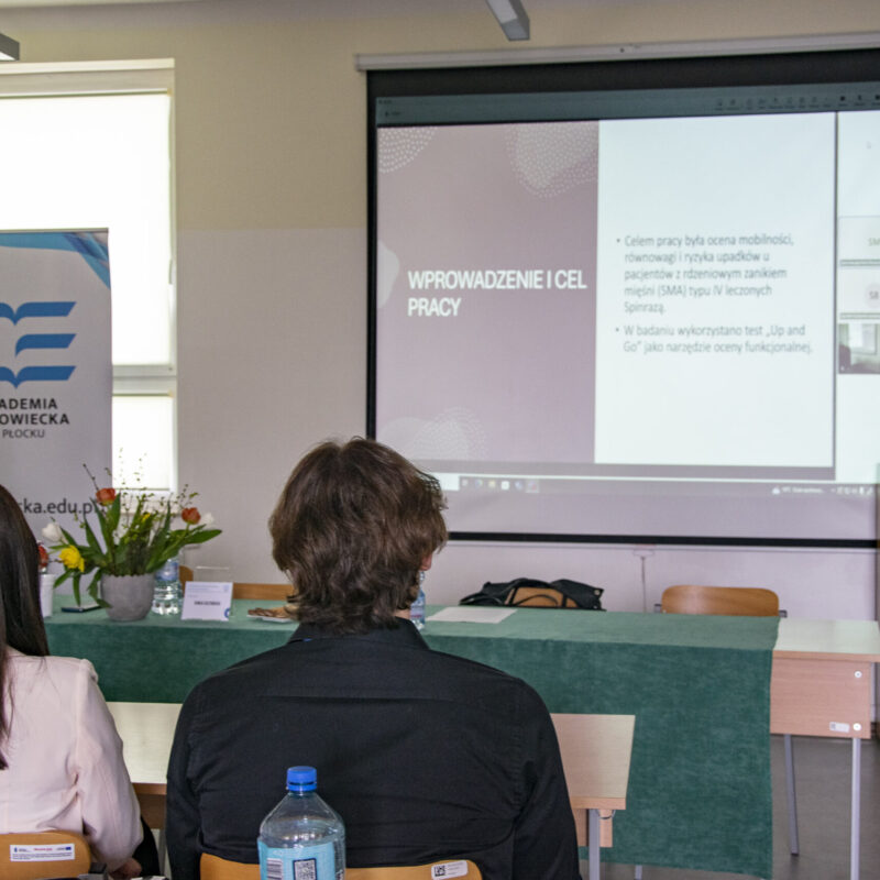 Studenci siedzący w sali wykładowej podczas prezentacji multimedialnej