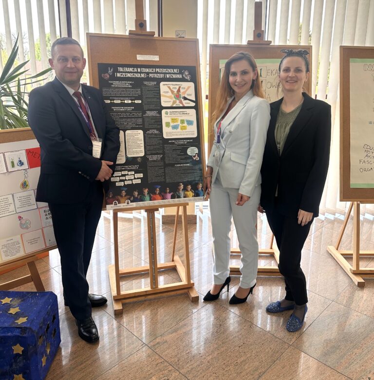 Od lewej doktorant i doktorantki szkoły doktorskiej AMP stojący przy sztaludze na której widnieje poster konferencyjny.