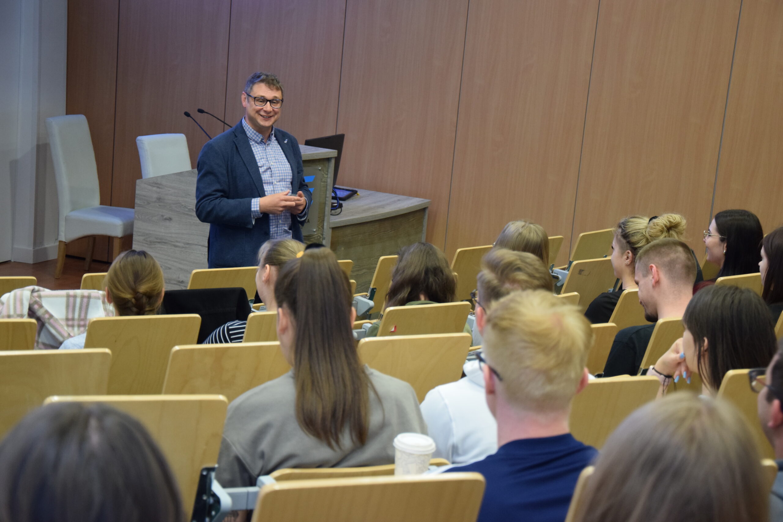 Gość wykładu otwartego przemawiający do zebranych na auli studentów
