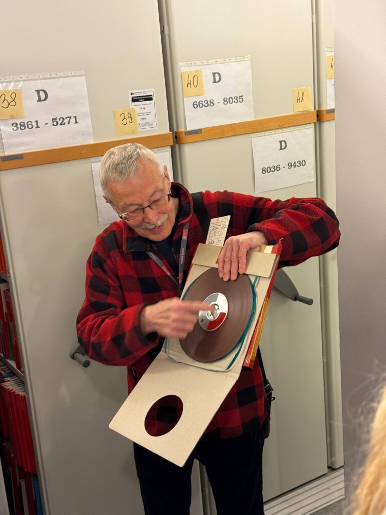 lektor Andrzej Krusiewicz pokazujący studentom płytę winylową
