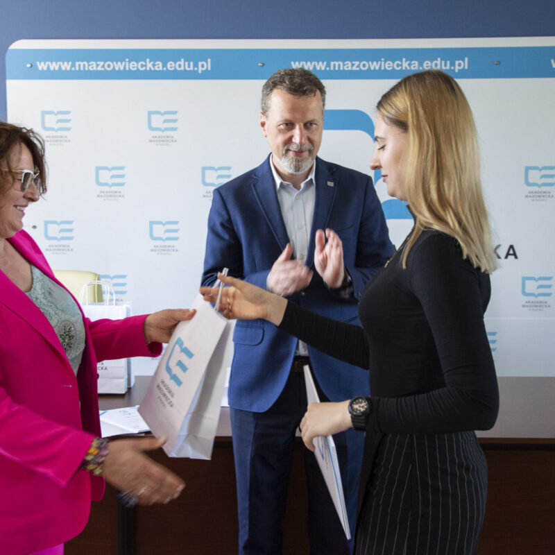 Rektor wręczający dyplom studentce, w towarzystwie Pani prorektor