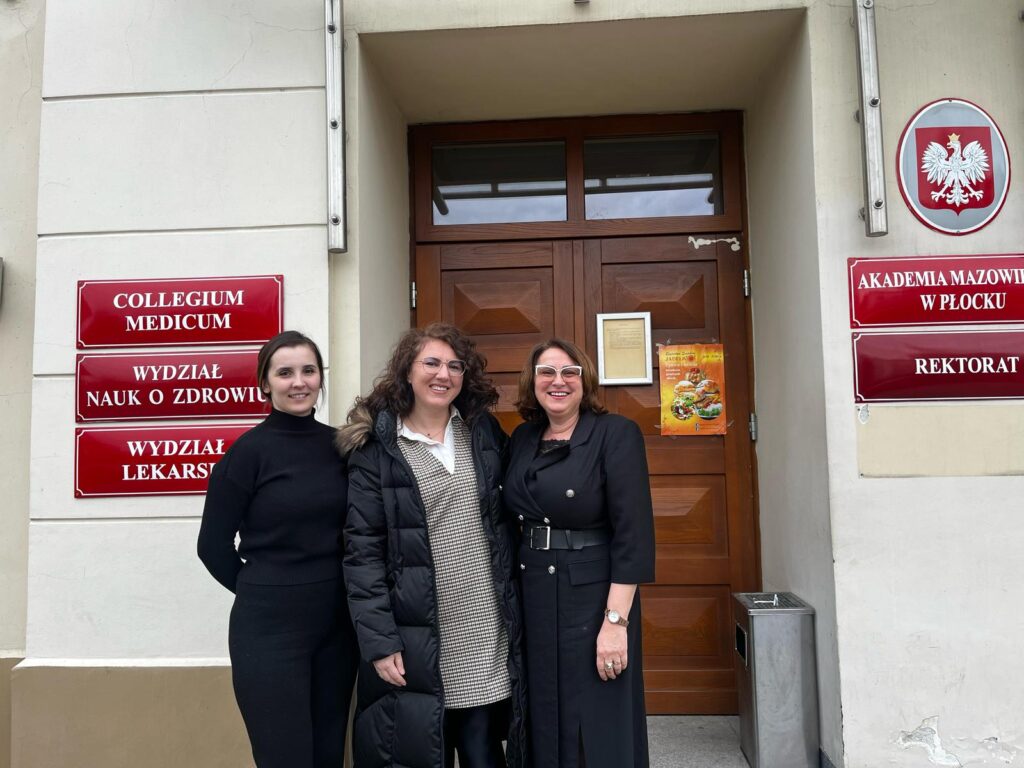 Prorektor ds. Collegium Medicum, wykładowca AMP i gość z Kosowa pozujące przed wejściem do Uczelni