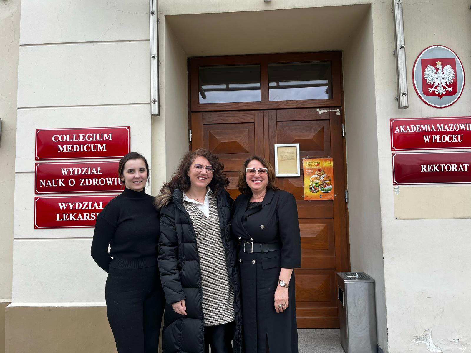 Prorektor ds. Collegium Medicum, wykładowca AMP i gość z Kosowa pozujące przed wejściem do Uczelni
