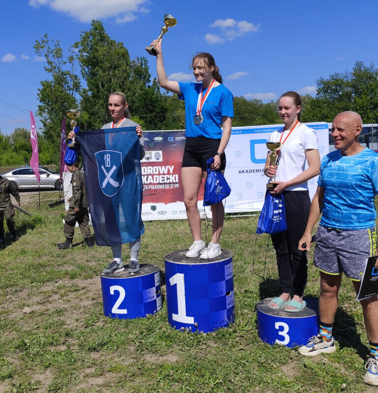 zawodniczki na podium trzymajace puchary