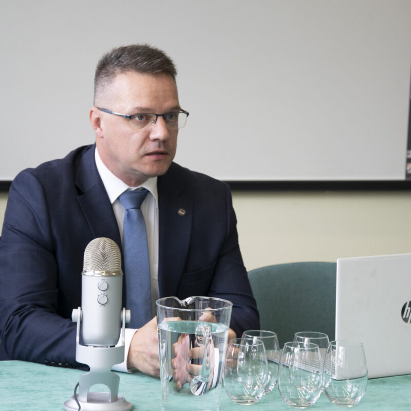 Prelegent podczas wystąpienia przy stole prezydialnym